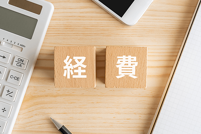 木製ブロックに「経費」と書かれ、周囲に電卓とノートが見えるイメージ画像